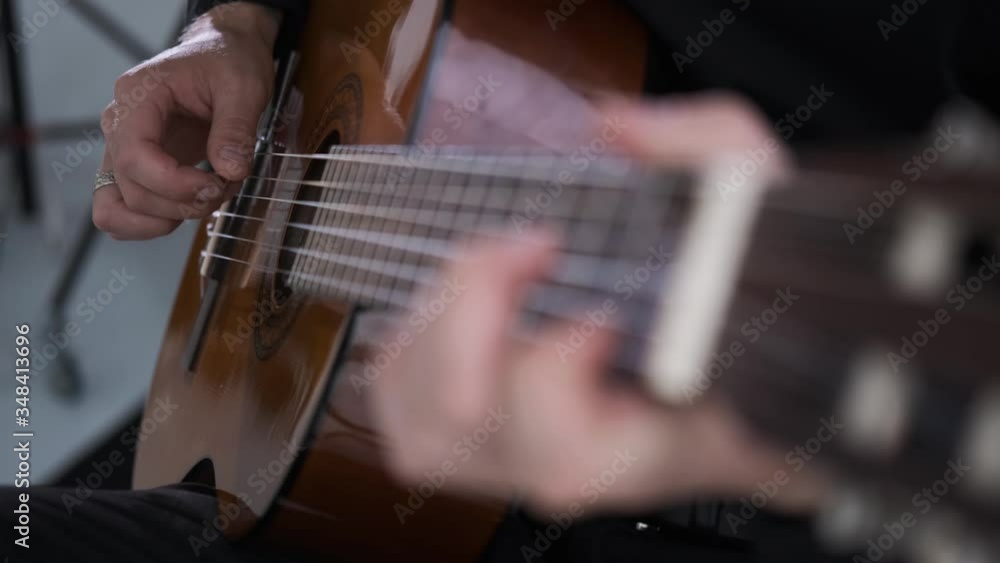 man plays an acoustic guitar in music Studio,large frame,young artist, creative concept,caucasian,close up man plays an acoustic guitar in music Studio,large frame,young artist, creative concept,caucasian,close up