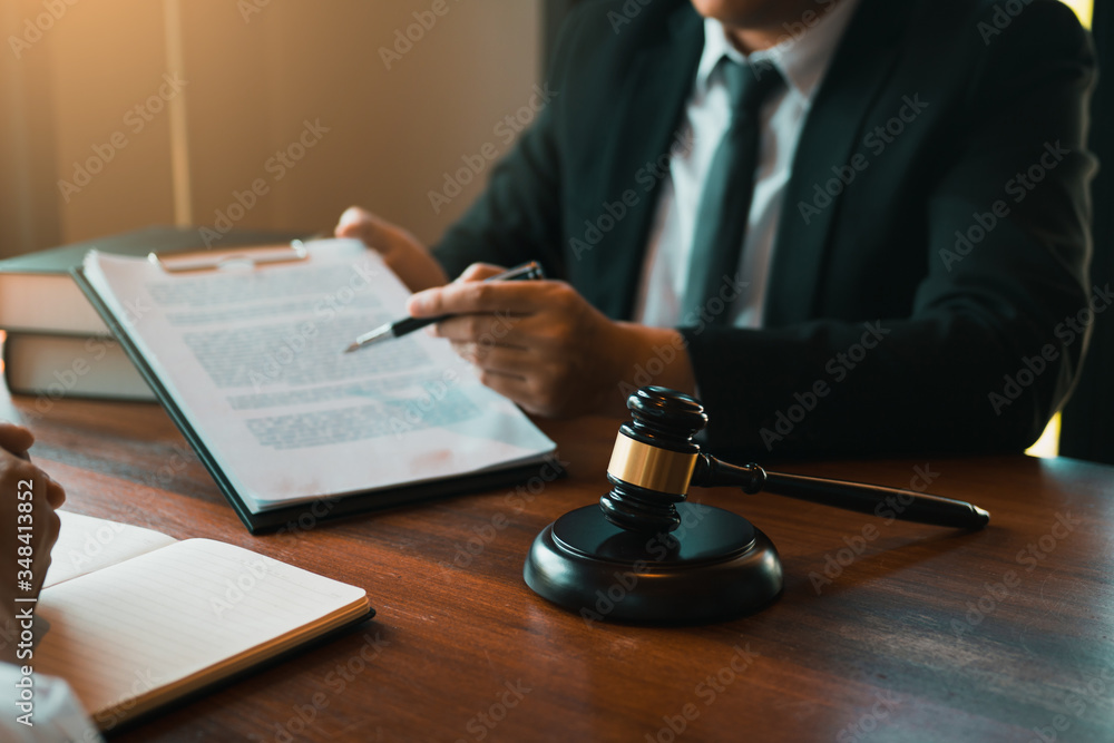 Legal advisor is explaining the offense under the law in the book at office. Legal advisor is explaining the offense under the law in the book at office.