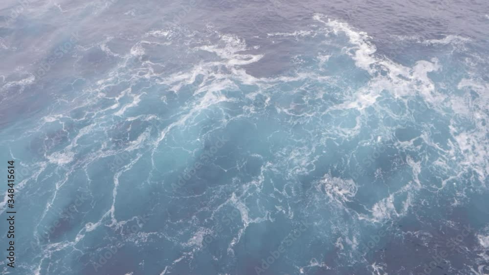 Ice blue water rushing past the bow of a sailing cruise ship with white foam splashing past, filmed looking directly down at 120fps slow motion Ice blue water rushing past the bow of a sailing cruise ship with white foam splashing past, filmed looking directly down at 120fps slow motion