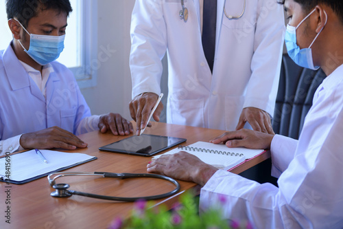 Video conferencing, concilium remote communication concept.Group of medics discuss x-ray scan.Team of doctors having meeting in clinic. photo