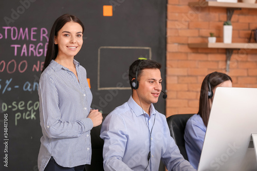 Professional technical support agent with team in office