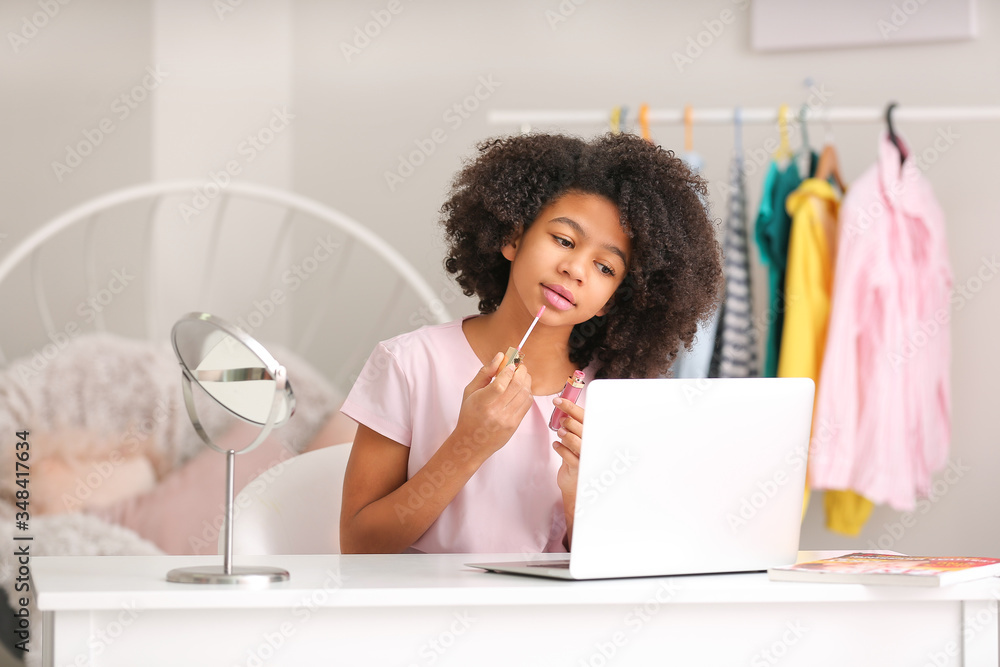 African-American teenage fashion blogger recording video at home
