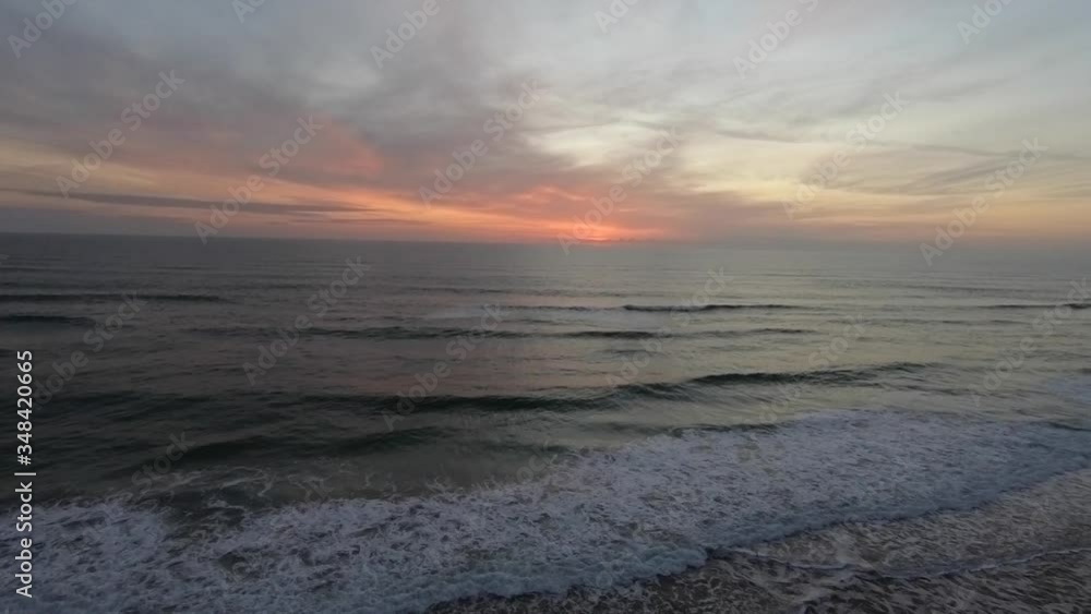 Beautiful sunrise with vibrant color as ocean waves crash. Beautiful sunrise with vibrant color as ocean waves crash.