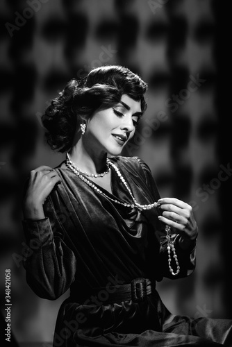 Happy romantic woman wearing vintage necklace and earrings, black and white photo