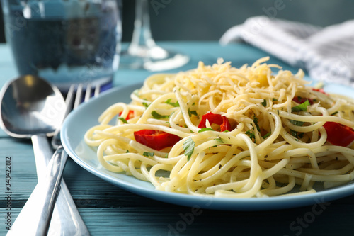 Composition with plate of tasty pasta on wooden background