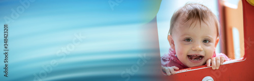 Cute baby girl having fun on a playground; panoramic banner