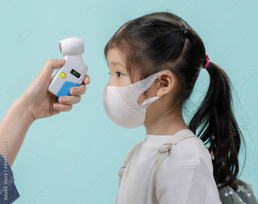 Mom and Asian little child girl wearing respirator mask to protect coronavirus outbreak and body temperature checked amid, New virus Covid-19 from Wuhan China concept, isolated on blue background Mom and Asian little child girl wearing respirator mask to protect coronavirus outbreak and body temperature checked amid, New virus Covid-19 from Wuhan China concept, isolated on blue background