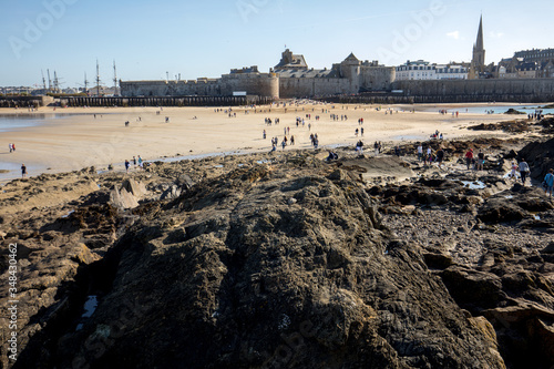 Romantic walk of people before sunset on the picturesque beach of Saint Malo. Brittany, France