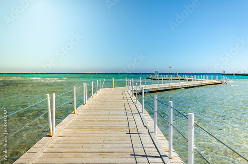 Wooden pier leading to the sea on a sunny day beautiful wooden pier leading to the sea with blue sky