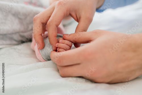 Family Baby Hands. Father and Mother Holding Newborn Kid. Child Hand Closeup into Parents