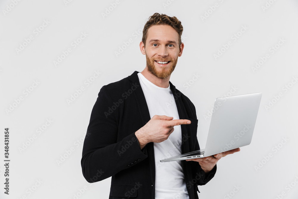 Image of happy man in jacket using and pointing finger at laptop Image of happy man in jacket using and pointing finger at laptop