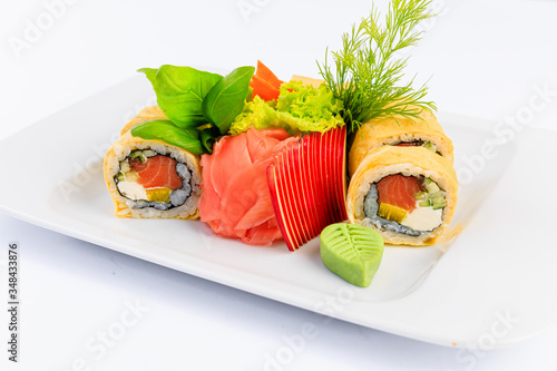 Sushi podane na białym talerzu, na jasnym świetlistym tle.