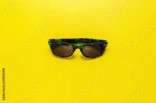 top view travel concept with shale, marine life, sunglasses on yellow background with copy space for text