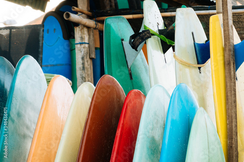 Close up Set of colorful surfboard for rent on the beach. Multicolored surf boards different sizes and colors surfing boards on stand, surfboards rental place