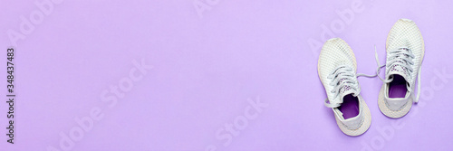 White running shoes on a purple background. Concept of running, training, sport. Banner. Flat lay, top view