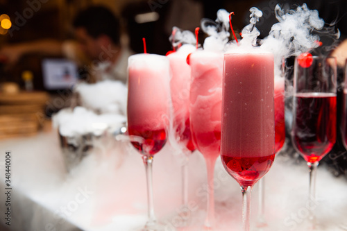 Glasses with a red drink are on the bar.