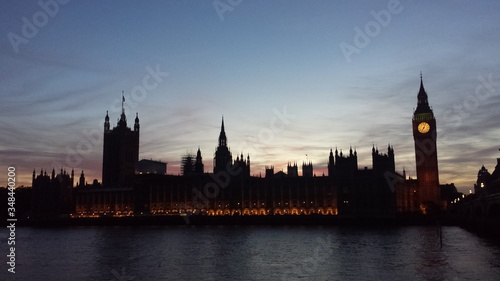 Fotografia Illuminated Palace Of Westminster By Thames River At Sunset