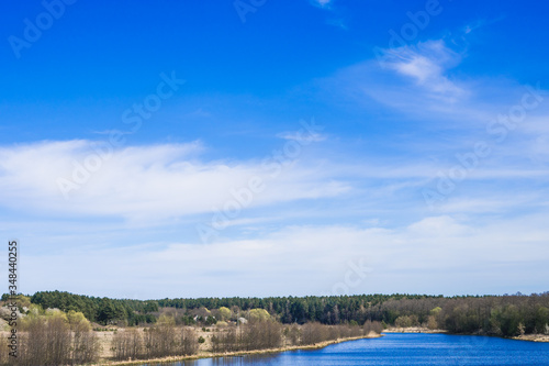 blue river with trees against the blue sky