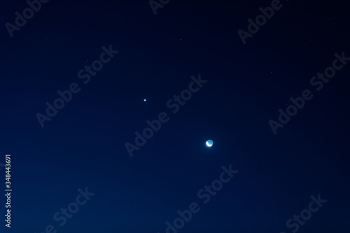 Young Moon and Venus on a dark night sky.