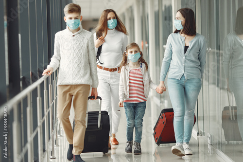 People in airport are wearing masks to protect themselves from virus.