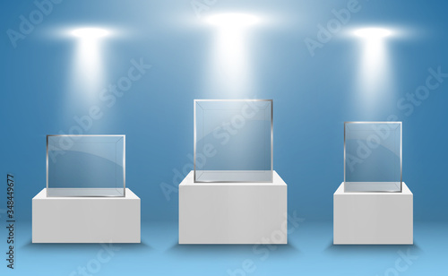 Glass showcase for the exhibition in the form of a cube. Background for sale illuminated by spotlights. Museum glass box isolated advertising or business design boutique. Exhibition hall.