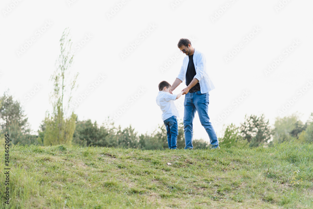 father and son have fun together in nature. Father and son playing. People having fun outdoors. Concept of friendly family. father and son have fun together in nature. Father and son playing. People having fun outdoors. Concept of friendly family.