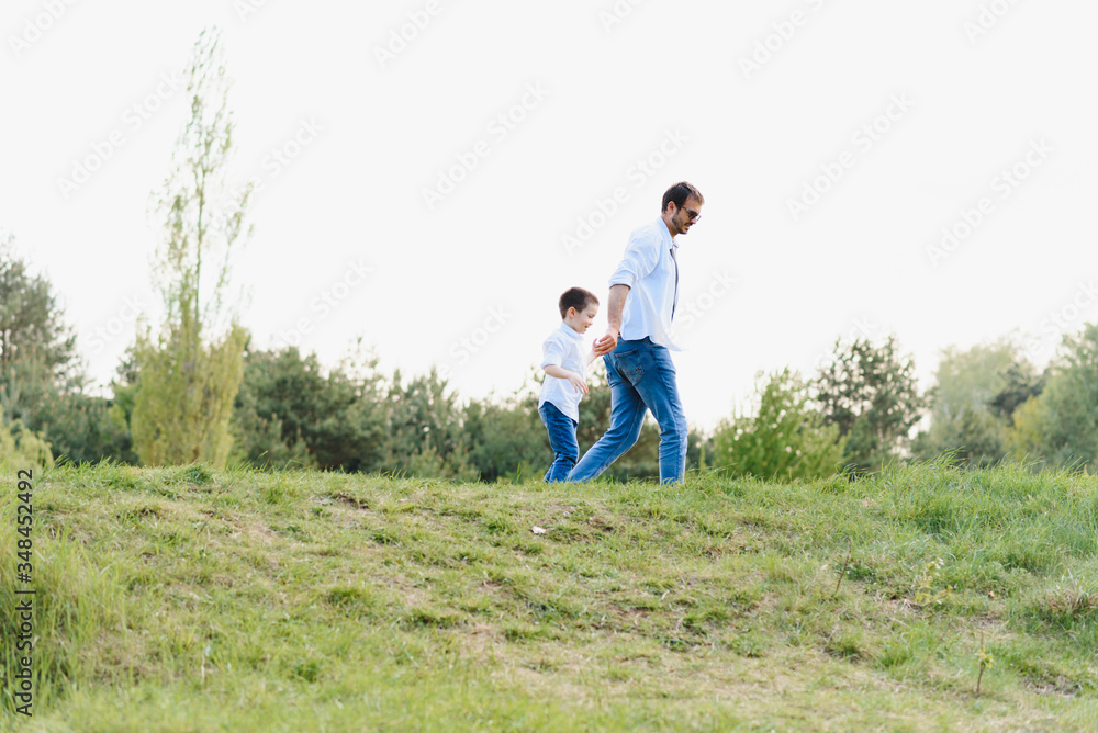 father and son have fun together in nature. Father and son playing. People having fun outdoors. Concept of friendly family. father and son have fun together in nature. Father and son playing. People having fun outdoors. Concept of friendly family.