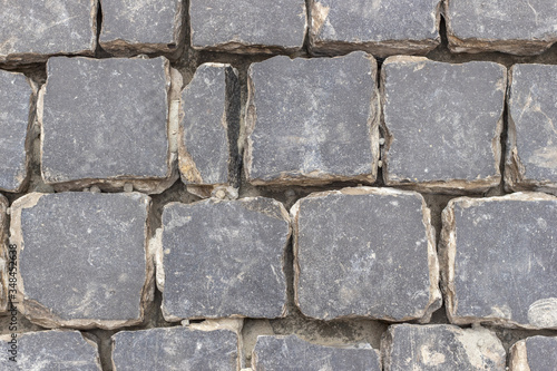 Road repair. Laying of pavement of black basalt. Cobblestones close up, top view.