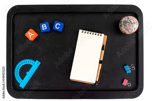 Back to school background with accessories for the schoolroom - notepad, globe, protractor, letters a b c on blackboard