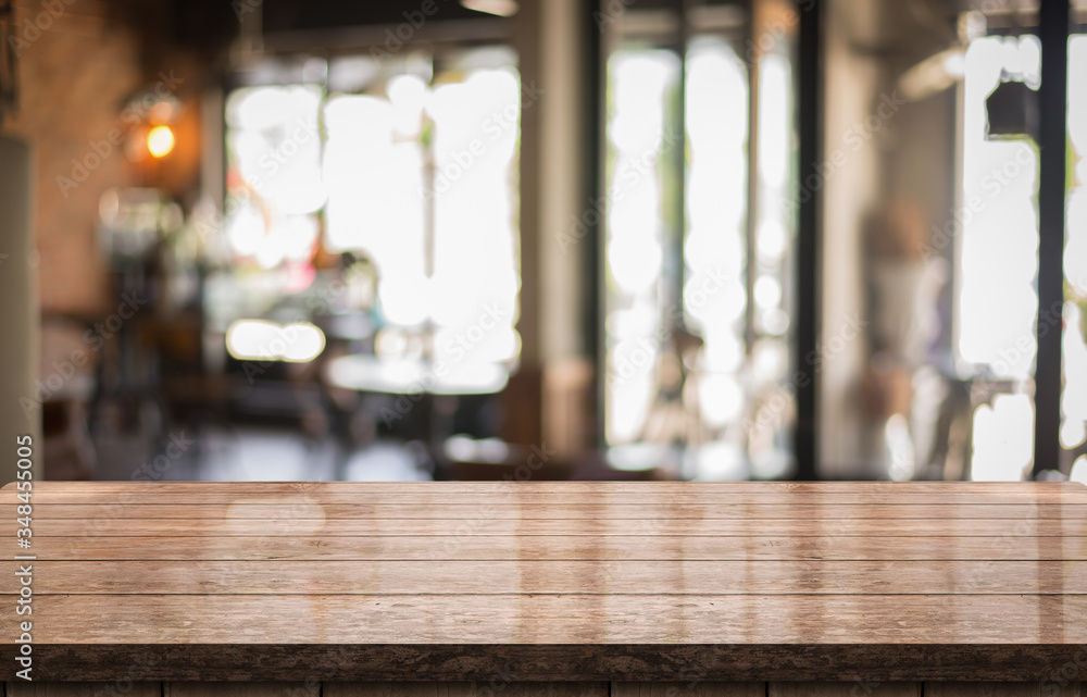 Empty old wood table top with bokeh coffee shop interior background.