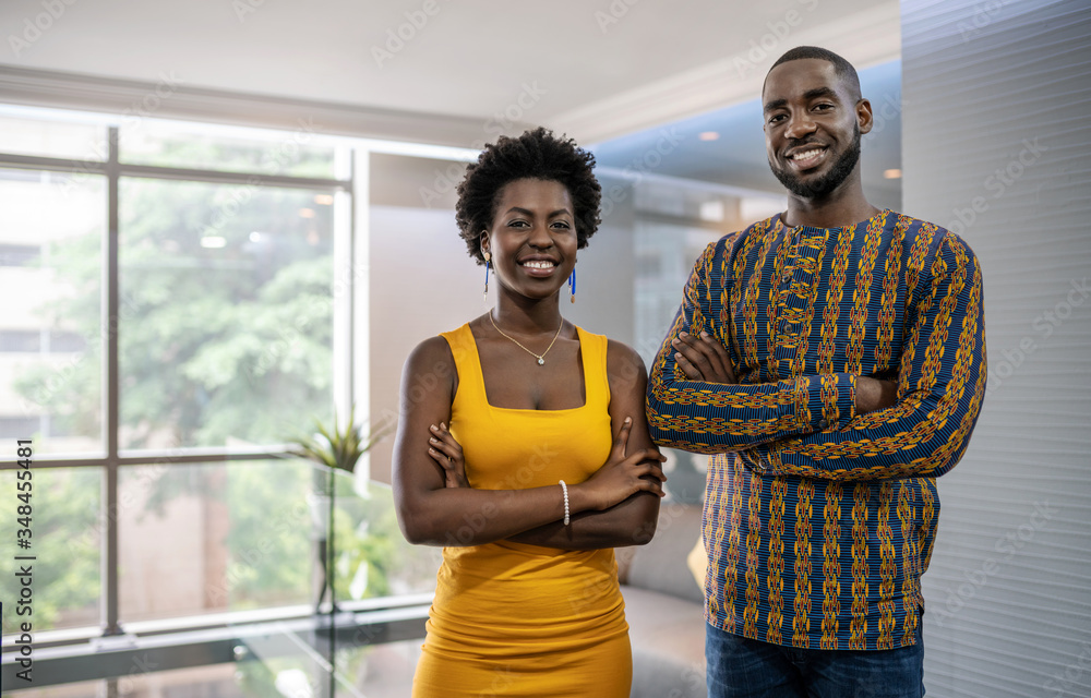 © JonoErasmus - Two confident young African businesspeople standing in a modern
