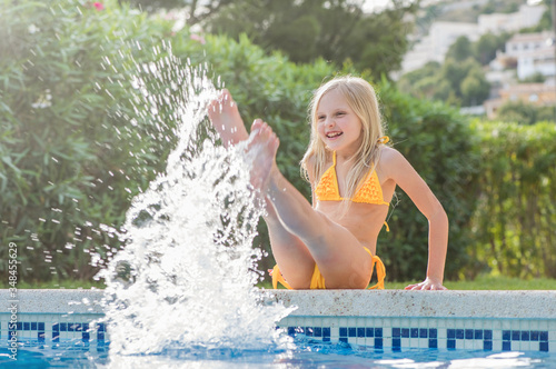 Summertime fun. Happy girl in pool in sunny day. Vacations.