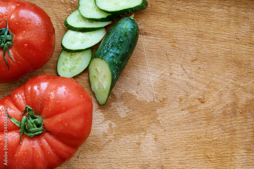 Tomatoes and cucumber on a wooden cutting board. Scratch Tomatoes and cucumber on a wooden cutting board. Scratch