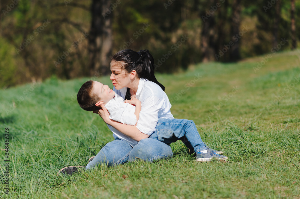Happy family! Mother with son child playing having fun together on the grass in sunny summer day, life moment Happy family! Mother with son child playing having fun together on the grass in sunny summer day, life moment