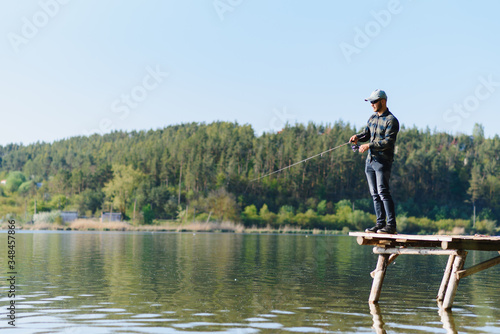 A man catches a fish on a spinning fishing in the summer