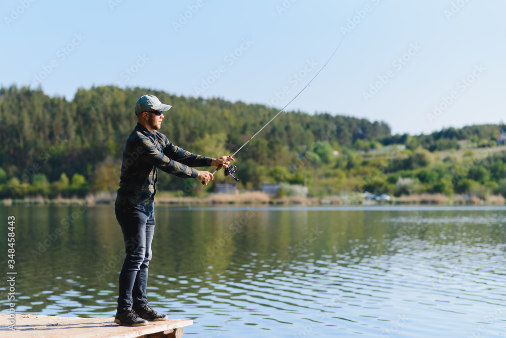 A man catches a fish on a spinning fishing in the summer A man catches a fish on a spinning fishing in the summer