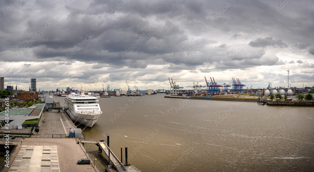 Panorama of a container terminal and industrial facilities in the port of Hamburg with a cruise liner