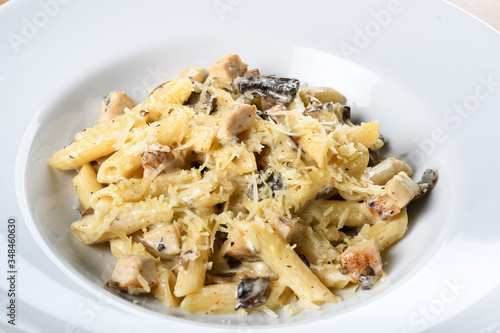 Traditional authentic italian penne al pollo e funghi pasta with mushroom ,chicken, parmesan cheese. photo