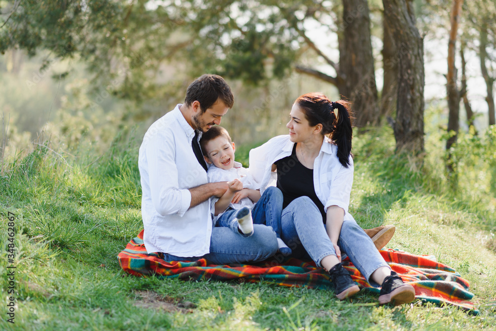 Family having a great time in the park. Father hugs son. Happy family on nature Family having a great time in the park. Father hugs son. Happy family on nature