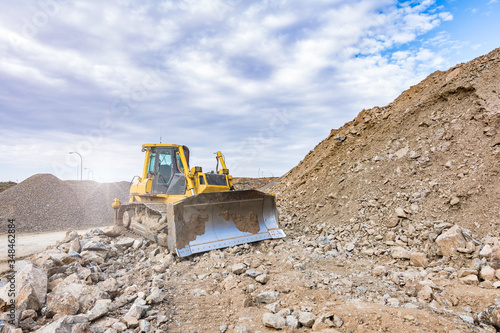 Excavator moving stone and rock at a construction site