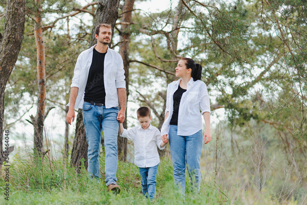 Fototapeta premium Dad, mom and little son having fun together, outdoors. Family walk in park. Happy family outdoors. Family, vacation concept