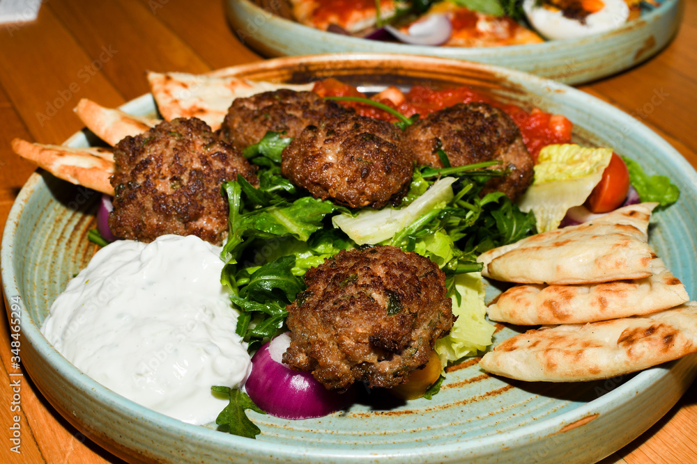 Mediterranean meatballs with salad, chickpeas with tomato sauce, yogurt dip and pita bread Mediterranean meatballs with salad, chickpeas with tomato sauce, yogurt dip and pita bread