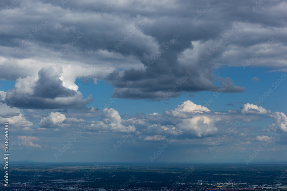 Obraz premium Aerial view from mountain Medvednica on Zagreb city, small in the distance, with beautiful white clouds high in the sky