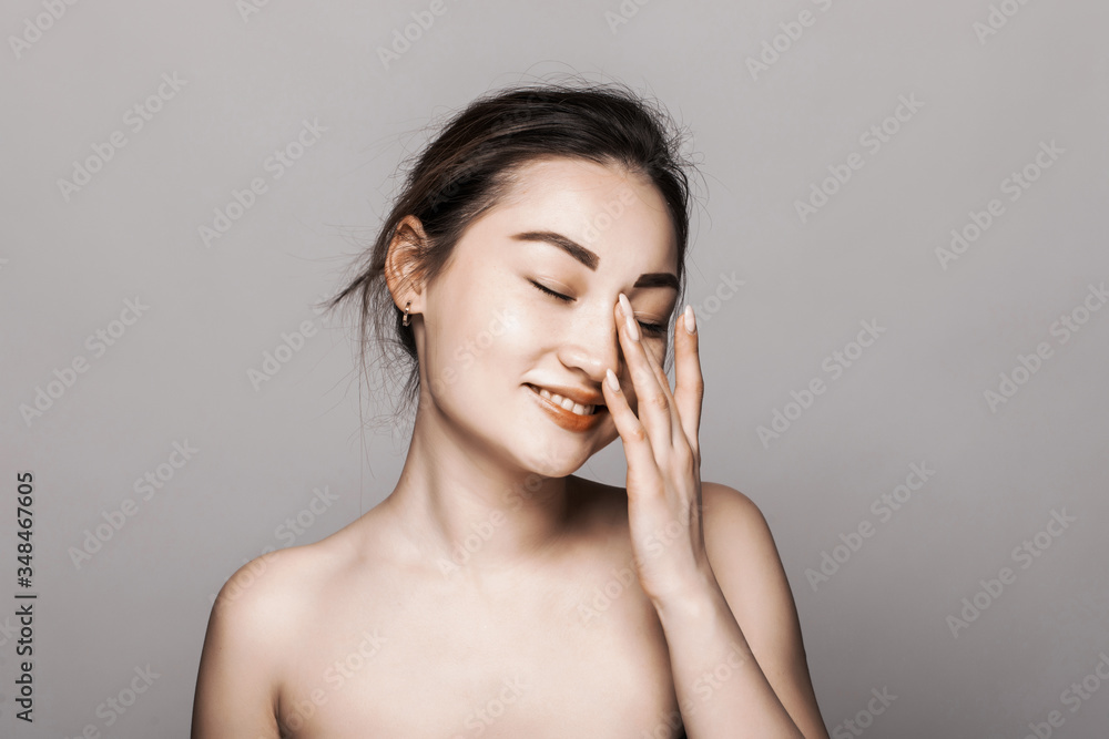 Young attractive asian woman skin care on gray background Young attractive asian woman skin care on gray background