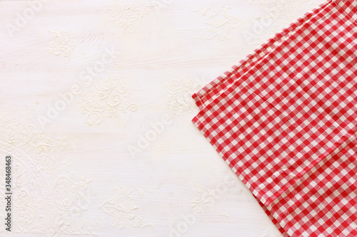 top view of checkered tablecloth with over white wooden background