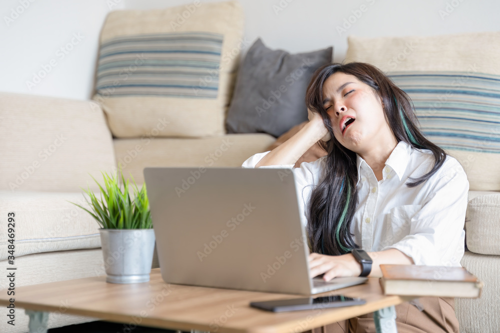 Beautiful young asian employee in casual wear feeling tired exhausted during working day in home office. Working from home concept Beautiful young asian employee in casual wear feeling tired exhausted during working day in home office. Working from home concept