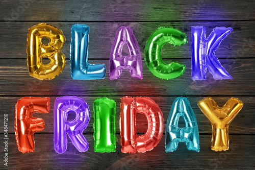 Phrase BLACK FRIDAY made of foil balloon letters on wooden background