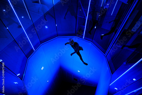 A man flier doing stunts in an indoor wind tunnel