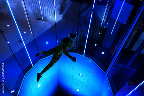 A man flier doing stunts in an indoor wind tunnel