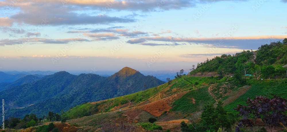 A beautiful green mountain range in Northern Thailand in the morning with winding along the side of the mountain.